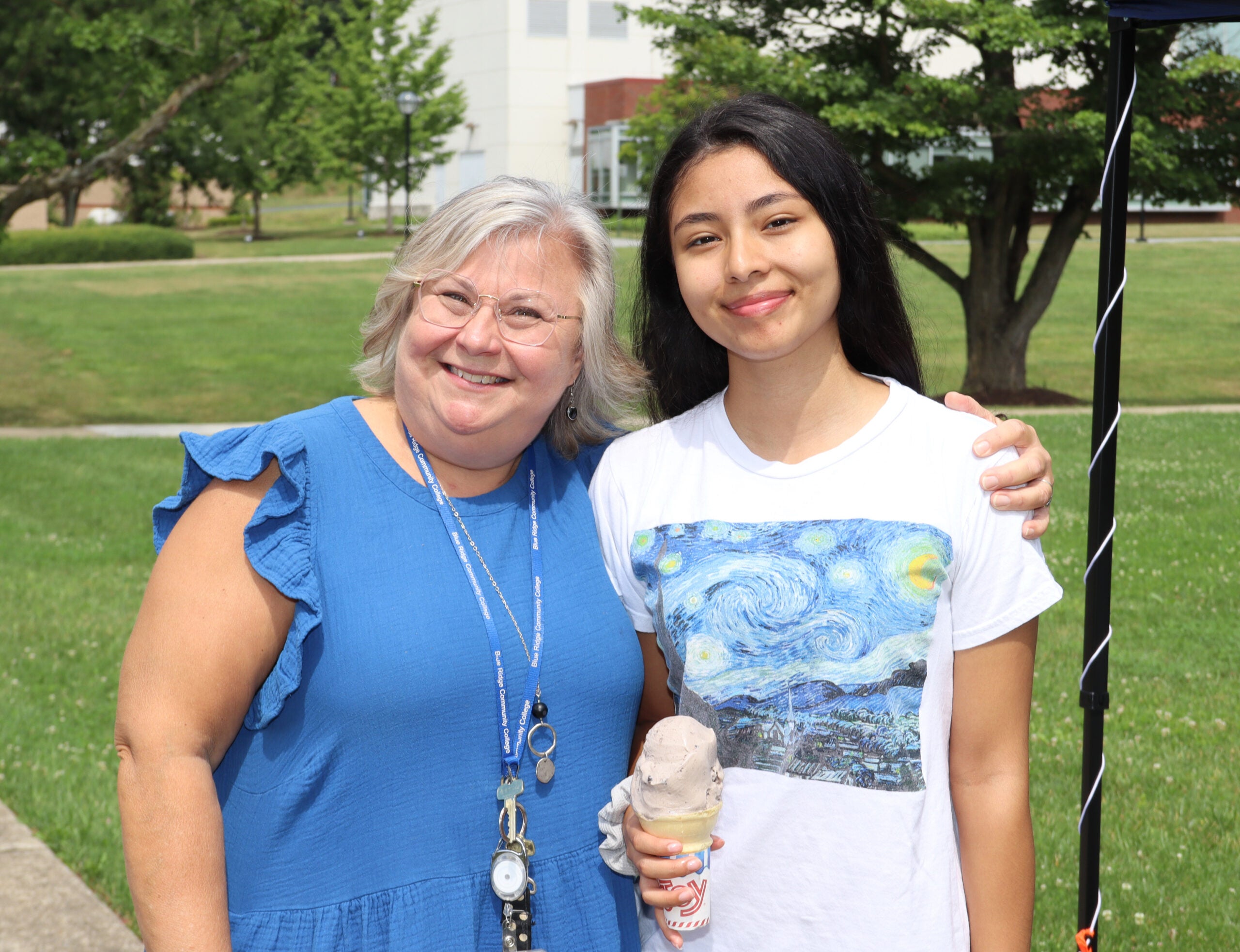 student smiling with staff member