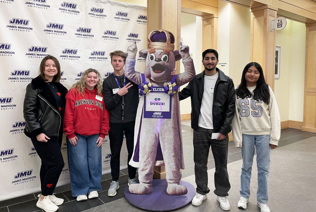 Student group at JMU posing with a cardboard Royal Dukes mascot