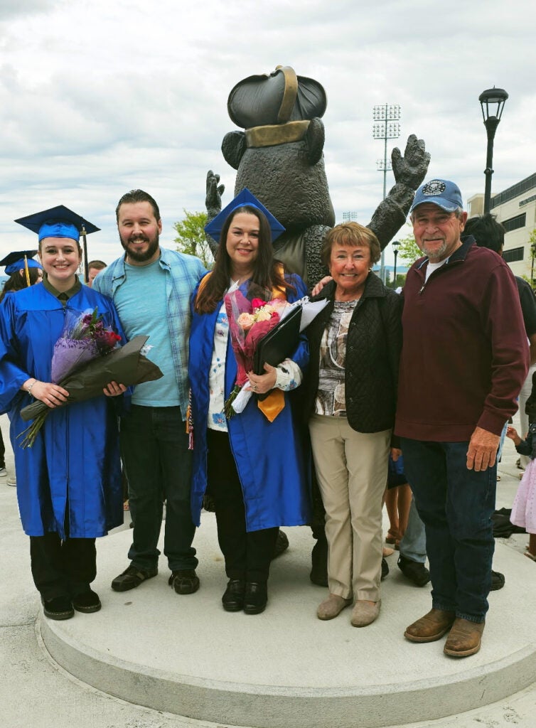A family with two women in graduation gowns
